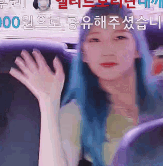 a woman with blue hair waves her hand in front of a sign that says ' 000 '