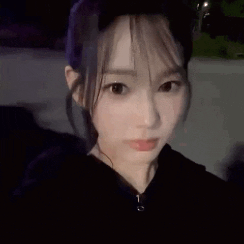 a close up of a woman taking a selfie with her eyes closed and a surprised look on her face .