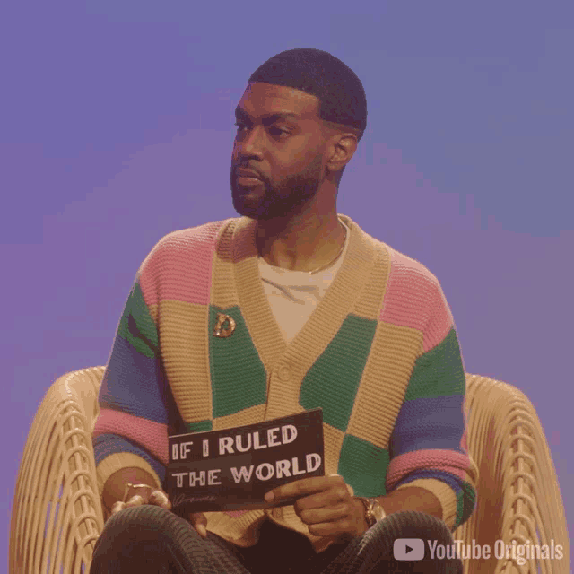 a man sitting in a chair holding a sign that says " if i ruled the world "