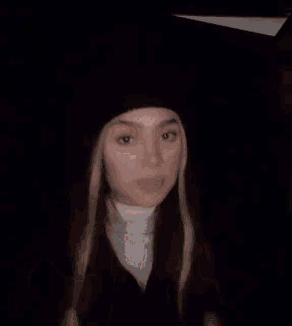 a woman is giving the middle finger in a dark room .