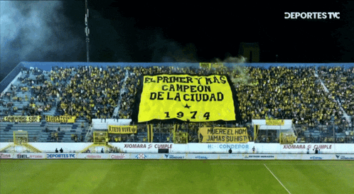 a stadium full of people with a banner that says el primer y mas campeon de la ciudad 1974