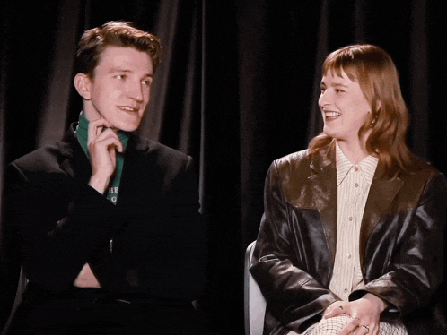 a man wearing a green shirt with the word object on it is laughing with a woman
