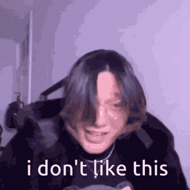 a person with long hair is making a funny face with the words `` i don 't like this '' behind them .