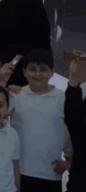 a group of young boys are standing next to each other and smiling .