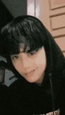 a close up of a person wearing a black hoodie and headphones