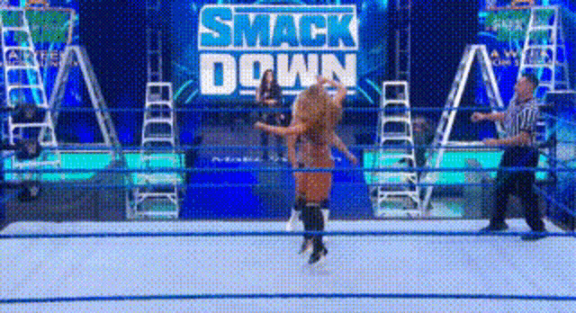 a wrestler is jumping in the air in a wrestling ring .