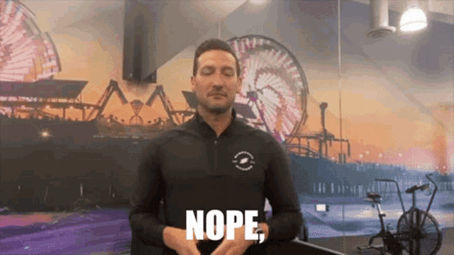 a man wearing a black shirt with the word nope on it