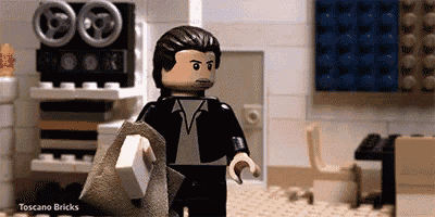 a lego man in a suit and tie is holding a piece of paper in a room .