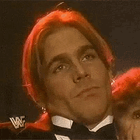 a close up of a man 's face with a wwe logo in the corner