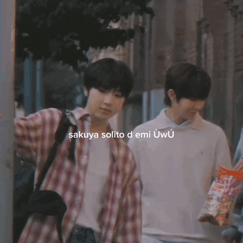 a man in a plaid shirt is standing next to another man in a white shirt