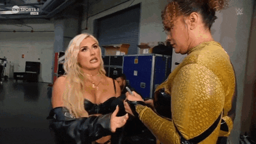 two women are standing next to each other in a room with the words tnt sports live on the bottom right