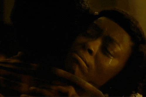 a man and a woman are hugging each other in a dark room