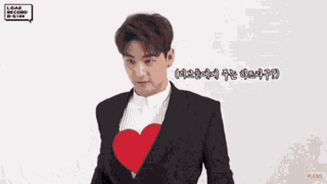a man in a suit with a red heart on his chest