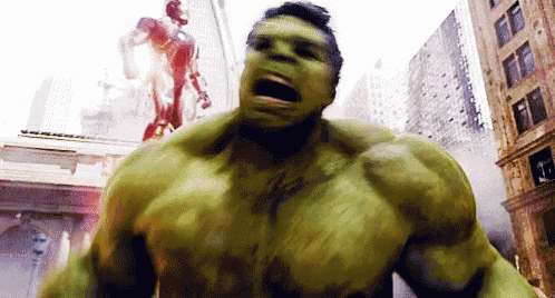 the hulk is standing in the middle of a city with his mouth open .