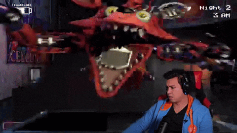 a man wearing headphones is playing a video game called five nights at freddy 's at night 2