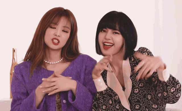 two women are standing next to each other and smiling