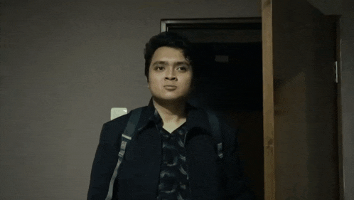 a man with a backpack is standing in a doorway