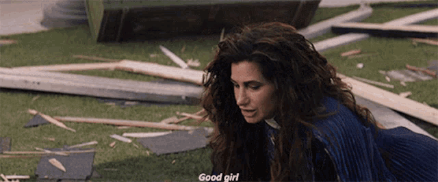 a woman with curly hair is laying on the ground and talking to another woman .
