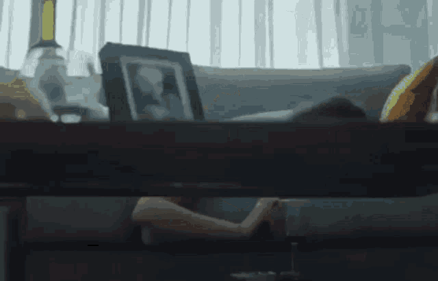 a person is laying on a couch with a picture of a child on the table