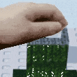 a pixel art of a person 's hand reaching out towards a green building .