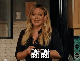 a woman in a black shirt is giving a thumbs up in chinese