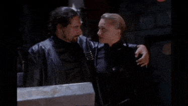 a man and a woman are hugging in a dark room .