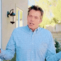 a man in a blue and white plaid shirt is standing in front of a house .