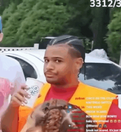 a man in a red shirt and orange vest is holding a cup of coffee .