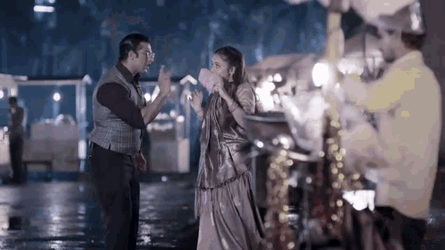 a man and a woman are standing next to each other eating cotton candy in the rain .