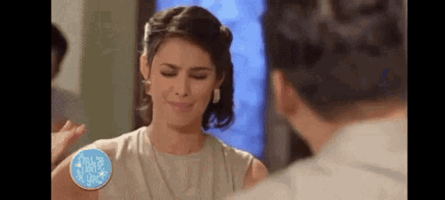 a woman is crying in front of a mirror while a man looks on .