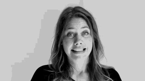 a black and white photo of a woman making a face .