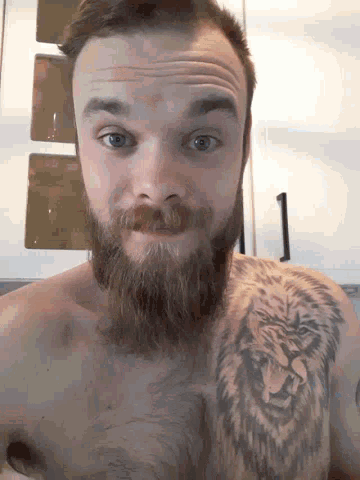a man with a beard has a tattoo of a lion on his arm