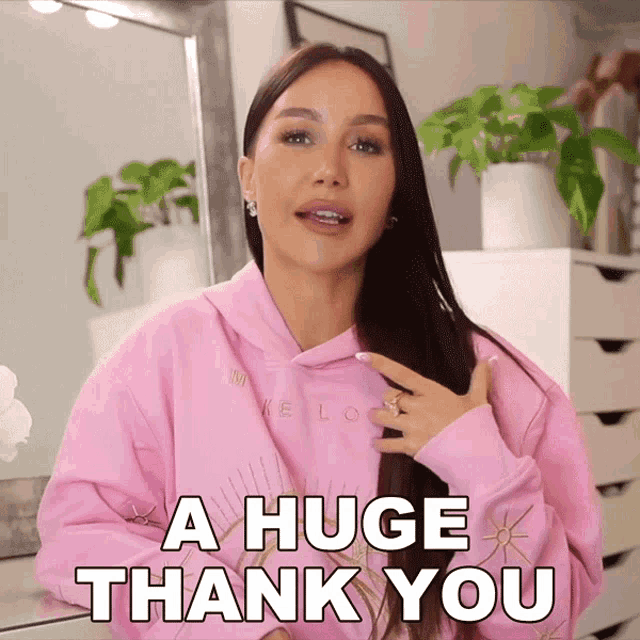 a woman wearing a pink sweatshirt says a huge thank you
