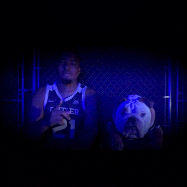a man wearing a butler jersey holds his finger to his lips