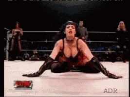a woman is laying on the ground in a wrestling ring with adr written in the corner
