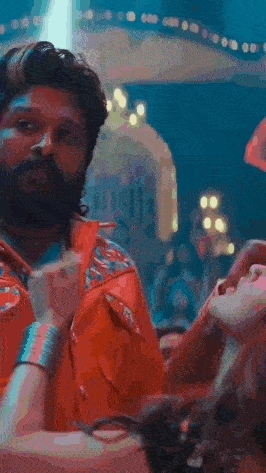 a man with a beard is touching a woman 's hand in a blurry photo .