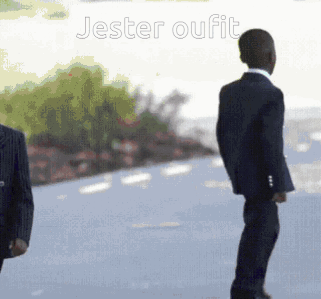 a man in a suit is standing in front of a sign that says jester oufit on it