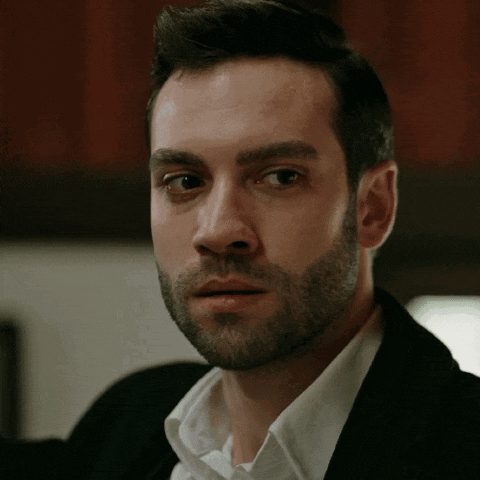 a man with a beard wearing a black jacket and white shirt