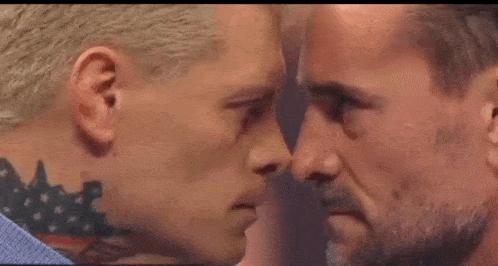 two men are looking at each other with their eyes closed .
