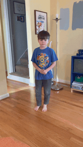 a young boy wearing a blue shirt with a picture of bart bart on it