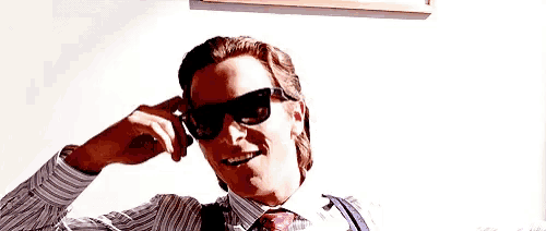 a man in a striped shirt and tie wearing sunglasses