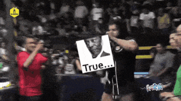 a man holding a sign that says true