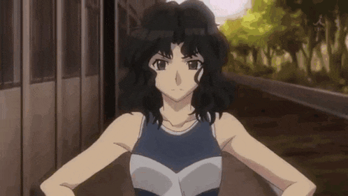 a girl with black hair is standing with her hands on her hips and looking at the camera .