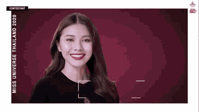 a woman is smiling and looking at the camera while wearing a black shirt and red lipstick .