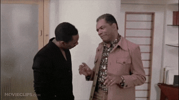 two men standing next to each other in a room with movieclips.com on the bottom right