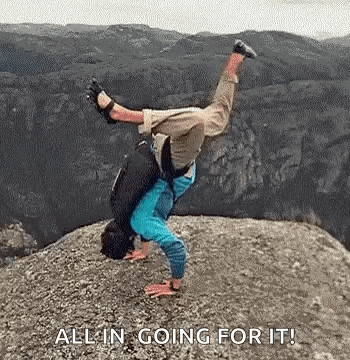 a man is doing a handstand on top of a rocky mountain .