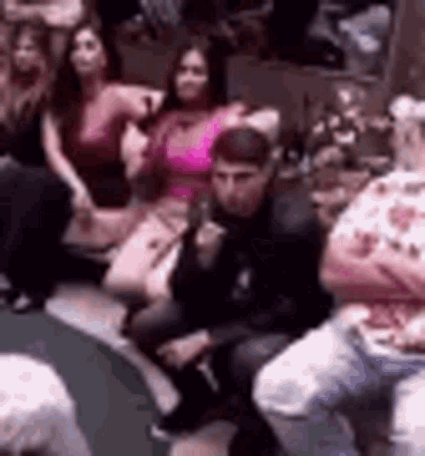 a group of people are sitting in a room with their arms crossed .