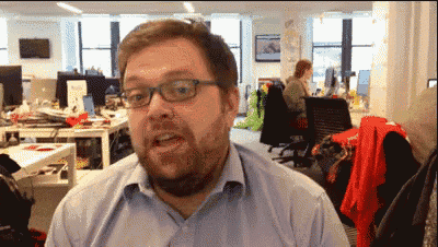 a man with glasses and a beard is looking at the camera