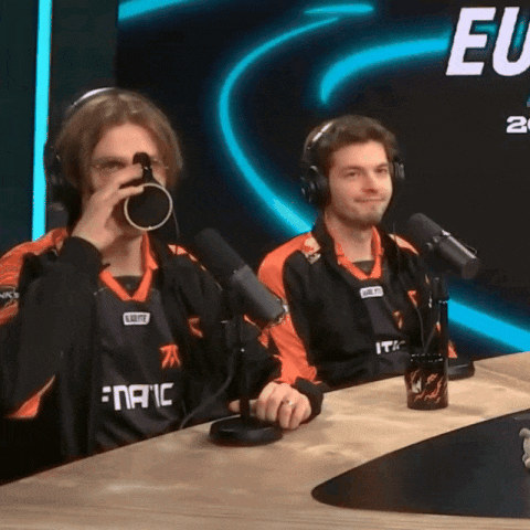 two men are sitting at a table with microphones and one of them is wearing a shirt that says fanaic