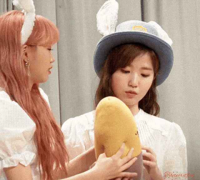 two girls wearing bunny hats holding a stuffed animal